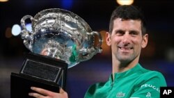 Serbia's Novak Djokovic holds the Norman Brookes Challenge Cup after defeating Russia's Daniil Medvedev in the men's singles final at the Australian Open tennis championship in Melbourne, Feb. 21, 2021.