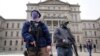 Two men with rifles stand outside the state Capitol in Lansing, Michigan.