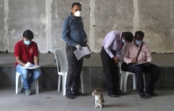 FILE - Indian journalists fill out forms for a swab test during a lockdown to control the spread of the coronavirus, in Mumbai, India, April 16, 2020.