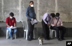 FILE - Indian journalists fill out forms for a swab test during a lockdown to control the spread of the coronavirus, in Mumbai, India, April 16, 2020.