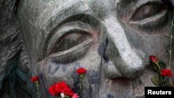 Flowers are placed on a monument inside the Athens' Polytechnic school, on the eve of the 41st anniversary of a 1973 student uprising against the then military ruling junta in Athens, Nov. 16, 2014.