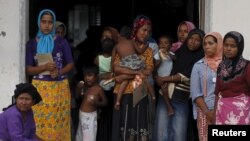 Rohingya migrant women, who recently arrived in Indonesia by boat, are seen inside a temporary compound for refugees in Aceh Timur regency, Indonesia's Aceh Province, May 21, 2015. (REUTERS/Beawiharta)