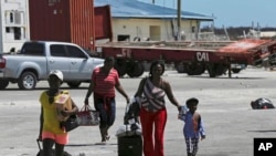Evacuees carry their belongings as they walk to a ferry to depart for Nassau in the aftermath of Hurricane Dorian, at the port of Marsh Harbor, Abaco Island, Bahamas, Sept. 8, 2019.