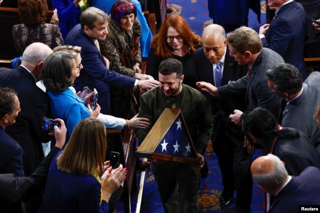 Ukraine's President Volodymyr Zelenskyy carries a U.S. flag presented to him by U.S. House Speaker Nancy Pelosi (D-CA) during a joint meeting of the U.S. Congress in the House Chamber of the U.S. Capitol in Washington, Dec. 21, 2022.