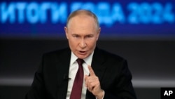 Russian President Vladimir Putin gestures as he speaks during his annual news conference and call-in show in Moscow, Russia, on Dec. 19, 2024, with the words "Results of the year 2024" in the background.