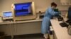 A member of medical personnel works with collected nose swab samples for a COVID-19 PCR test at the MontLegia CHC hospital, during a gradual lifting of a lockdown to prevent the spread of the coronavirus, in Liege, Belgium, Friday, May 8, 2020. (AP…