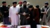 FILE - Afghan Sikh men mourn fellow believers killed by an Islamic State gunman, during their funeral in Kabul, Afghanistan, March 26, 2020. 