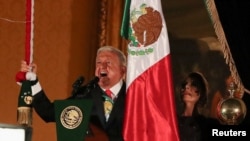 El presidente de México, Andrés Manuel López Obrador, toca una campana mientras grita el "Grito de Independencia" para conmemorar la Independencia de México de España, en el Palacio Nacional, en la plaza Zócalo en el centro de Ciudad de México, México, 15 de septiembre de 2024.