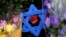 FILE - A Star of David fashioned from ice pop sticks hangs from bushes outside the Tree of Life Synagogue in Pittsburgh, Nov. 20, 2018. 