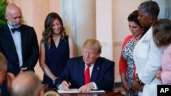 President Donald Trump signs an executive order that calls for upfront disclosure by hospitals of actual prices for common tests and procedures to keep costs down at the White House in Washington, June 24, 2019. 