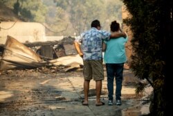 Eyed Jarjour, left, comforts a neighbor who lost her Jolette Avenue home to the Saddleridge Fire, Oct. 11, 2019, in Granada Hills, Calif.