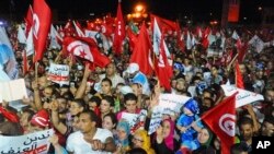 Para pendukung partai Islamis Ennahda melambaikan bendera dan berbagai spanduk sambil meneriakkan slogan mereka dalam aksi demo di Tunis, Tunisia (3/8).