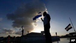 Ciudadanos enarbolan la bandera nacional de Nicaragua durante una protesta en Managua, el 1 de junio de 2018.