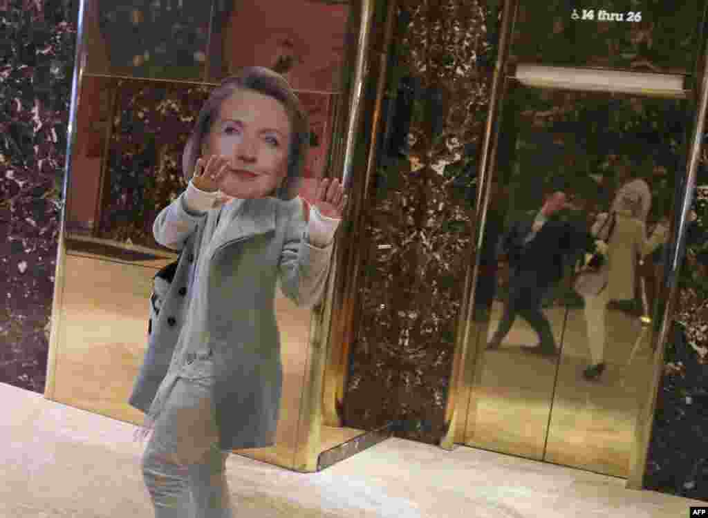 A man wearing a Hillary Clinton mask walks through Trump Tower in New York.