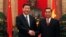 FILE - China's Vice President Xi Jinping (L) poses for a photo with Vietnam's Communist Party's Senior Politburo member Le Hong Anh in front of a bust of late Vietnamese revolutionary leader Ho Chi Minh at the Presidential Palace in Hanoi, Dec. 21, 2011.