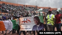 Des partisans du GPS, la formation politique de l'ancien Premier ministre Guillaume Soro, affichent un poster à son effigie au stade d'Abidjan, en Côte d'Ivoire, le 10 octobre 2020.