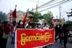 Anti-coup protesters march with a banner reading 'Mya Taung Strike' in Mandalay, Myanmar, March 26, 2021.