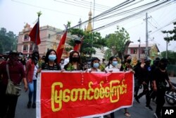 Anti-coup protesters march with a banner reading 'Mya Taung Strike' in Mandalay, Myanmar, March 26, 2021.
