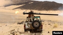 Seorang kombatan pemerintah Yaman menembakkan senjata dari kendaraan militer dalam baku tembak melawan milisi Houthi di Marib, Yaman, 9 Maret 2021.
