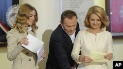 Polish Prime Minister Donald Tusk, center, his wife Malgorzata, right, and daughter, Katarzyna, cast their ballots during parliamentary elections in Warsaw, Poland, Sunday, October 9, 2011.