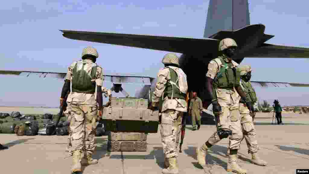 Nigerian soldiers prepare to load weapons stored in boxes into a military plane before leaving for Mali.