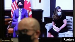 Perdana Menteri Kanada Justin Trudeaú dan Wakil Perdana Menteri Chyrstia Freeland tampak di layar video saat konferensi video dengan Presiden AS Joe Biden di Gedung Putih, Washington, Selasa, 23 Februari 2021. (Foto: Reuters)