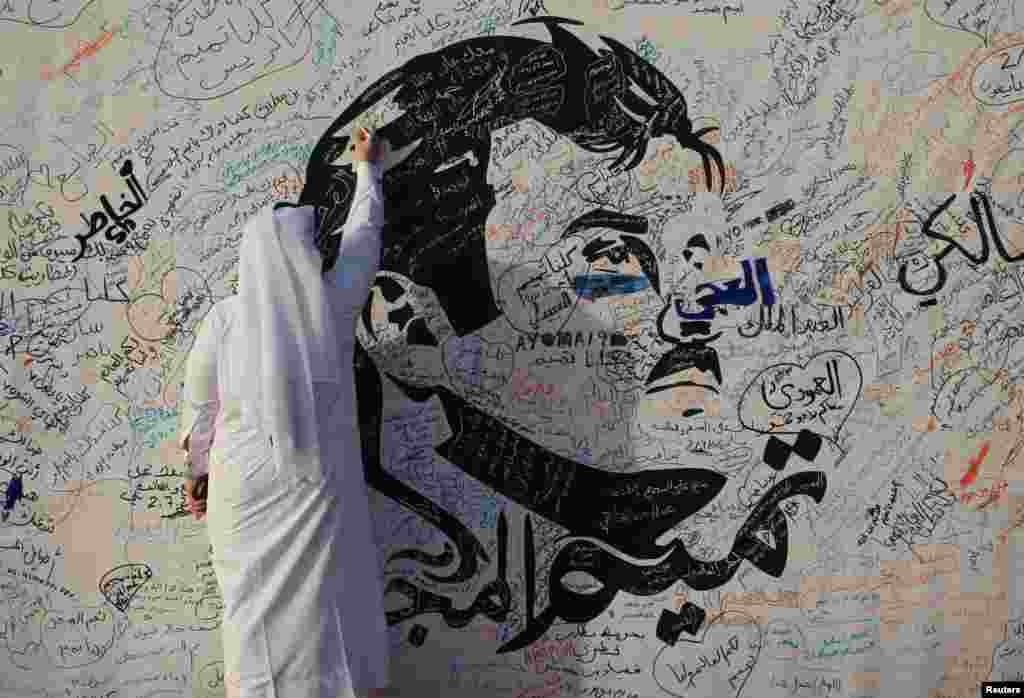 یک قطر عکس امیر این کشور را روی دیواری در دوحه می کشد. هنوز اختلاف قطر و عربستان حل نشده است.