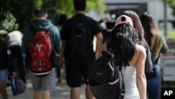 FILE - Students walk on the campus of Miami Dade College, in Miami, Oct. 23, 2018. 