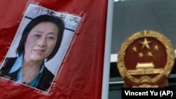 FILE - A picture of Chinese journalist Gao Yu is displayed during a protest calling for her release, outside the Chinese liaison office in Hong Kong, May 11, 2014.