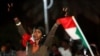 FILE - A woman flashes the victory sign during the first anniversary of the start of the uprising that toppled long-time ruler Omar al-Bashir, at the Friendship Hall in Khartoum, Sudan, Dec. 25, 2019. 