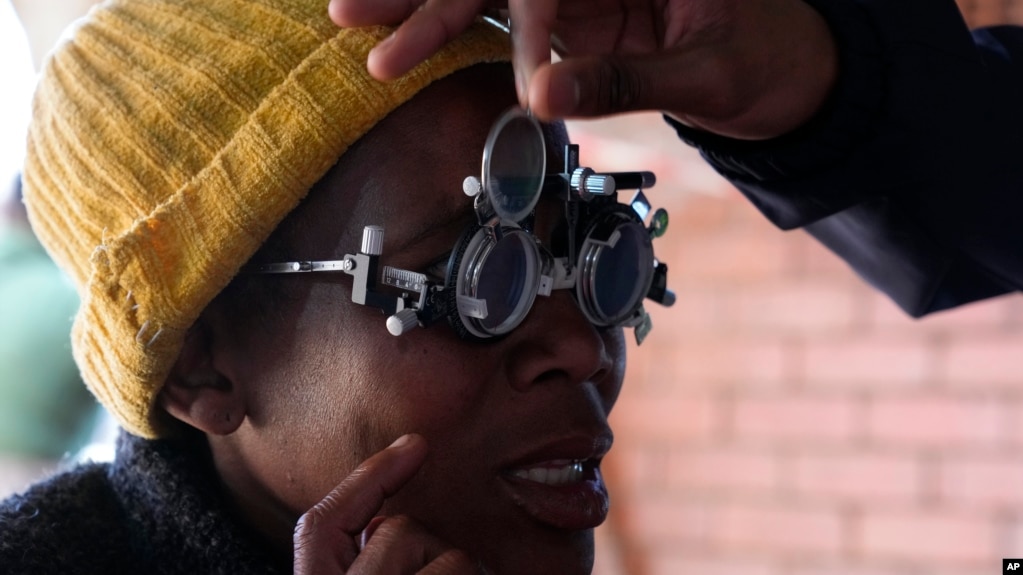 A patient eyes are tested for lenses to be made for a new pair of glasses outside the Phelophepa eye clinic carriage, in Tembisa, east of Johannesburg, South Africa, Thursday, Aug. 22, 2024. (AP Photo/Themba Hadebe)