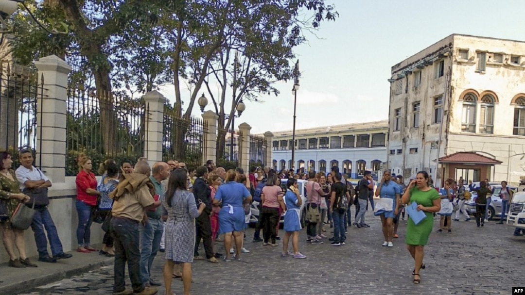 Para pekerja keluar dari gedung Lonja de Comercio setelah gempa mengguncang Havana, Kuba, 28 Januari 2020. (Foto: AFP)