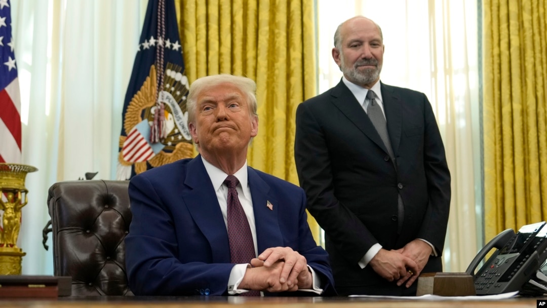 El presidente Donald Trump escucha una pregunta de un periodista mientras el candidato a secretario de Comercio, Howard Lutnick, observa después de que se firmara una orden ejecutiva en la Casa Blanca, el jueves 13 de febrero de 2025, en Washington. (Foto AP/Ben Curtis).