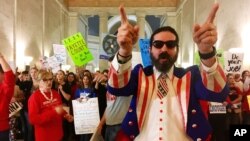 Parry Casto, a fifth-grade teacher at the Explorer Academy in Huntington, W.Va., dressed in an Uncle Sam costume, leads hundreds of teachers in chants outside the state Senate chambers at the Capitol in Charleston, W.Va., March 1, 2018. Senators refused to vote Friday on whether striking teachers should get a 5 percent pay raise.
