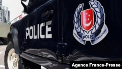 FILE - A police vehicle is seen parked on a street in Singapore, May 31, 2019.