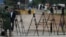 FILE - Pakistani journalists are seen at a stake-out in Islamabad, Pakistan, Nov. 6, 2013. Recently, a Pakistani government body, established to regulate private TV channels, has started asserting itself in ways that have raised concerns with media watchdogs.