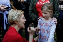 Democratic presidential candidate Sen. Elizabeth Warren, D-Mass., makes her signature pinky promise with Nora Showalter, 6, at a campaign event, Oct. 24, 2019, in Hanover, N.H.