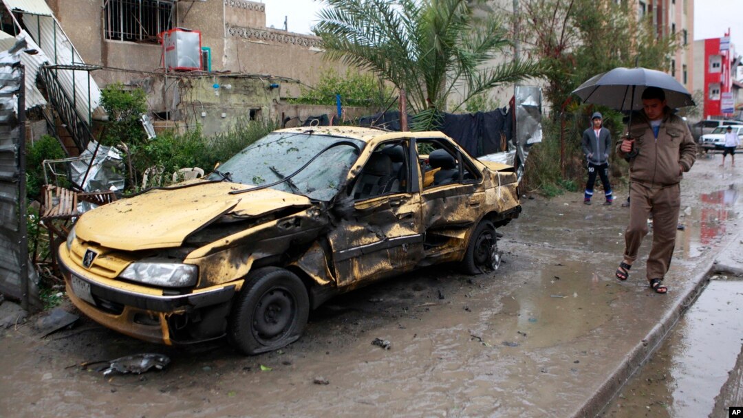 Seorang warga sipil Iran memeriksa lokasi ledakan bom mobil di wilayah komersial Hurriyah, utara Baghdad, Senin (3/2).