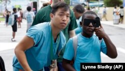 University of Miami medical student Francisco Halili helps a young man with an eye exam.