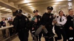 FILE - Occupy Wall Street activist Lauren Digioia is detained by police during a demonstration against the National Defense Authorization Act in New York's Grand Central Station, Jan. 3, 2012.