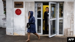 A security guard stands at the door of the building of the editorial office of Novaya Gazeta newspaper in Moscow, Russia, March 15, 2021.
