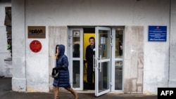 FILE - A security guard stands at the door of the building of the editorial office of Novaya Gazeta newspaper in Moscow, Russia, March 15, 2021.