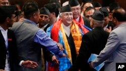 FILE - Nepal’s prime minister, Khadga Prasad Oli, center, speaks with members of his cabinet inside the Constituent Assembly in Kathmandu, Nepal, Oct. 11, 2015.