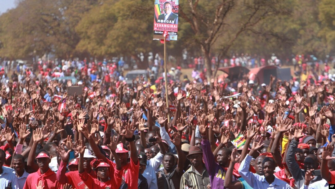 Supporters hold up a portrait of Zimbabwe Prime Minister Morgan Tsvangirai at his last campaign rally before elections set for Wednesday, in Harare, July 29, 2013. 