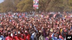 Supporters hold up a portrait of Zimbabwe Prime Minister Morgan Tsvangirai at his last campaign rally before elections set for Wednesday, in Harare, July 29, 2013. 