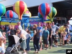 People wait in line to board rides at Gillian's Wonderland, the popular amusement park on the boardwalk in Ocean City, N.J., during its final day of operation before shutting down for good, Oct. 13, 2024.