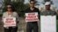 Israeli Arab supporters of Mohammed Allan, a Palestinian prisoner on a hunger strike, hold signs during a support rally outside Barzilai hospital, in the costal city of Ashkelon Israel. Israel passed a law to force feed hunger strikers by a slim margin in July and elicited harsh criticism, August 11, 2015.