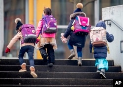 FILE - In this Feb.16, 2021 file photo, young children go to school in Frankfurt, Germany. In many schools, students get a look at careers from as early as age 10. (AP Photo/Michael Probst - FILE)