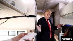 El presidente de Estados Unidos, Donald Trump, habla con periodistas a bordo de su avión oficial, el Air Force One, en ruta a Bedminster, New Jersey. Junio 29, 2018.