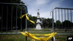 FILE - A statue of Christopher Columbus is seen behind barricades at Marconi Plaza, in Phalidelphia, Pennsylvania, June 15, 2020. A similar statue of Columbus was toppled by protesters in Baltimore, Maryland, July 4, 2020.